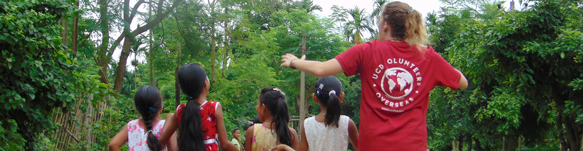Woman and children walking down a forested path